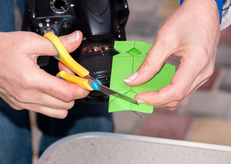 woman cuts scissors of green paper during a master class