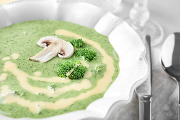 Plate with delicious broccoli cheese soup on table, closeup
