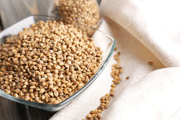 Glass bowl with hemp seeds on table
