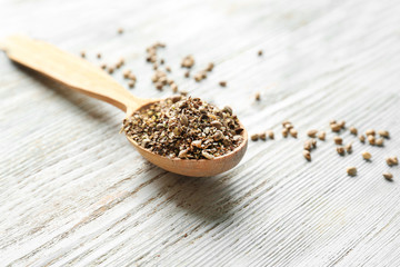 Spoon with hemp seeds on wooden background