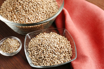 Bowls with hemp seeds on wooden table