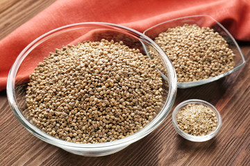 Bowls with hemp seeds on wooden table