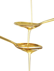 Two spoons and pouring cooking oil on white background