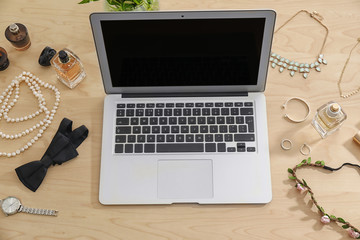Comfortable workplace with modern laptop and female accessories on table