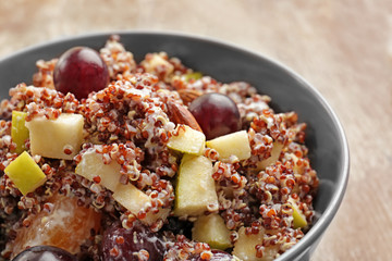 Salad with quinoa and fruits in bowl, closeup