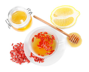 Composition with goji berries and tea on white background