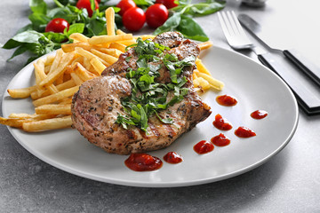 Plate with delicious grilled steak frites on kitchen table
