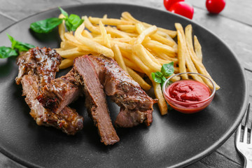 Plate with delicious grilled steak frites wooden table