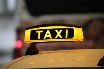 Taxischild auf Autodach mit Spiegelung, Schlange am Flughafen