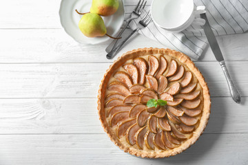 Tasty pear tart on white wooden table