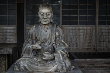 Wooden statue of a monk at wooden shrine itsukushimam, Miyajima, Japan