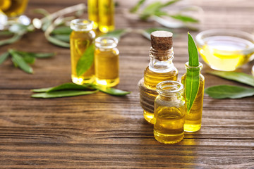 Glass bottles with olive oil on wooden table