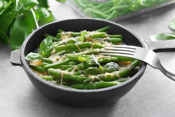 Frying pan with delicious green bean casserole on kitchen table