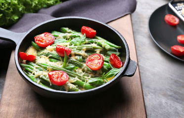 Frying pan with delicious green bean casserole on kitchen table