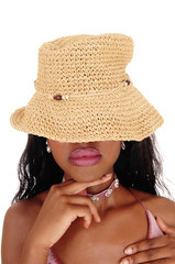 Young African woman with straw hat over eyes