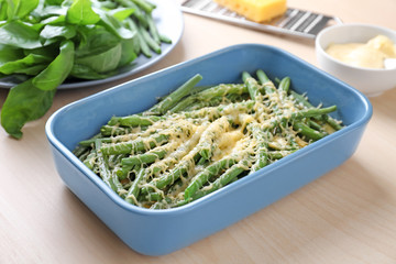 Baking dish with yummy green bean casserole on kitchen table
