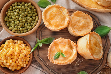 Delicious little meat pies on wooden board