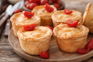Delicious little meat pies on wooden board