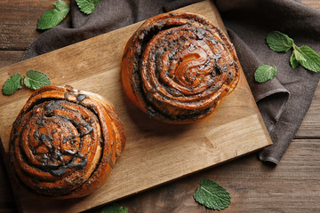 Tasty pastry with poppy seeds on wooden board