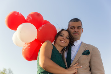 Young couple with red and white love baloons