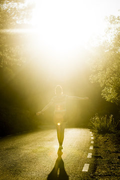 Woman Walking On Sunny Road