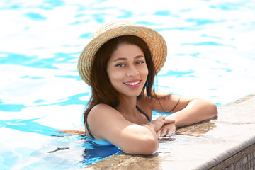 Beautiful young woman relaxing in swimming pool