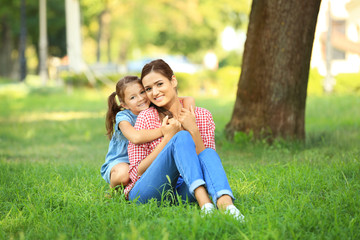 Fototapeta premium Cute little girl with mother in park on sunny day