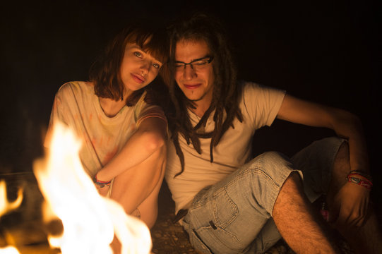 Couple sitting at bonfire