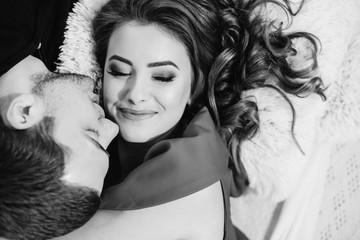 Fototapeta premium Tenderly kissing couple. Man and woman lying towards down. Kiss