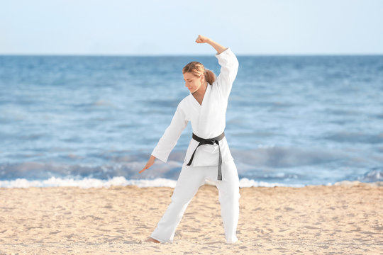 Young woman practicing karate outdoors