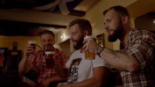 Good old friends drinking beer in a pub