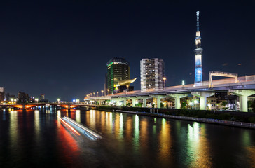 Obraz premium Skyline of Tokyo with skytree and river and lighttrails of boat at night, Tokyo, Japan
