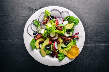 Avocado Salad with grilled meat and greens. Italian cuisine. Top view. On Wooden background.