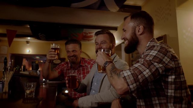 Good old friends drinking beer in a pub