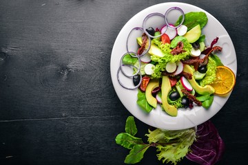 Avocado Salad with grilled meat and greens. Italian cuisine. Top view. On Wooden background.