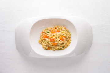 Risotto with pumpkin. Top view. Free space for text. On a wooden background.