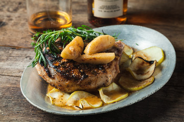 Grilled pork chop with bourbon spiced maple apples served with roasted potatoes