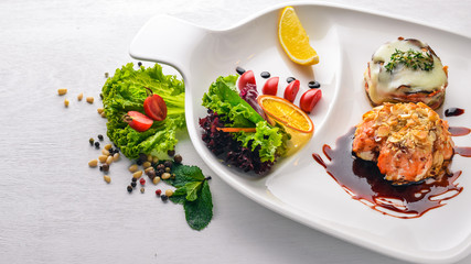 Baked salmon with grilled vegetables. Top view. Free space for text. On a wooden background.