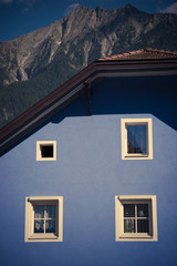 Fototapeta na wymiar Blue house with white windows under Alps