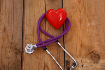 Heart with a medical stethoscope, isolated on wooden background