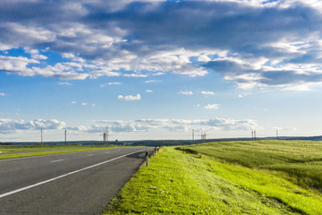 Fototapeta na wymiar Green field road. Car journey in the Belarus.