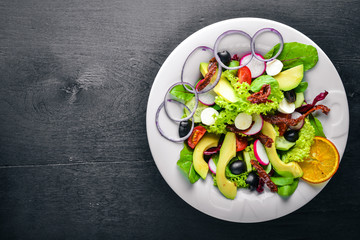 Avocado Salad with grilled meat and greens. Italian cuisine. Top view. On Wooden background.