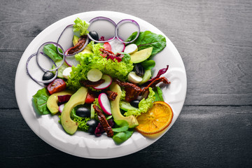 Avocado Salad with grilled meat and greens. Italian cuisine. Top view. On Wooden background.