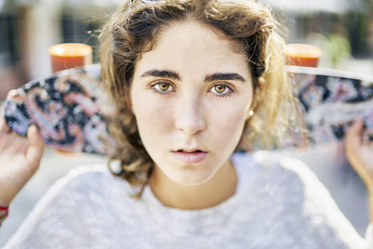 Portrait of teenage girl with skateboard