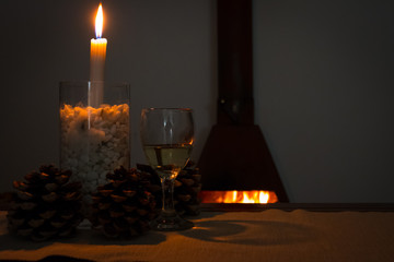 wine and fir cones in front of a fire