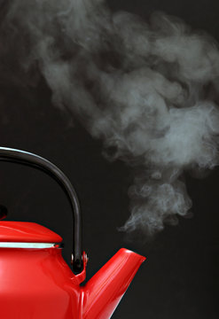 Red Kettle Steaming Hot Isolated on Black Background
