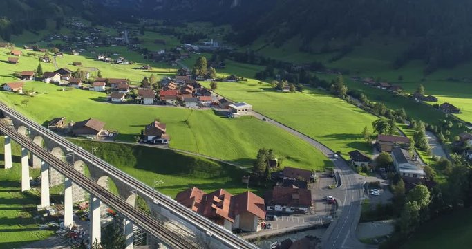 Automotive and railway aqueduct in alpine foothill in Switzerland. Scenic peaceful view of countryside life. Top view of traditional swiss beautiful village. Vacation and european destination concept