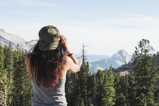 Woman with Binoculars Peering Out at Half Dome