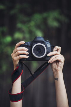 Woman holding camera at outdoors