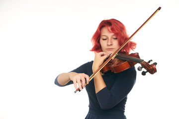 Beautiful young redhead woman playing the violin